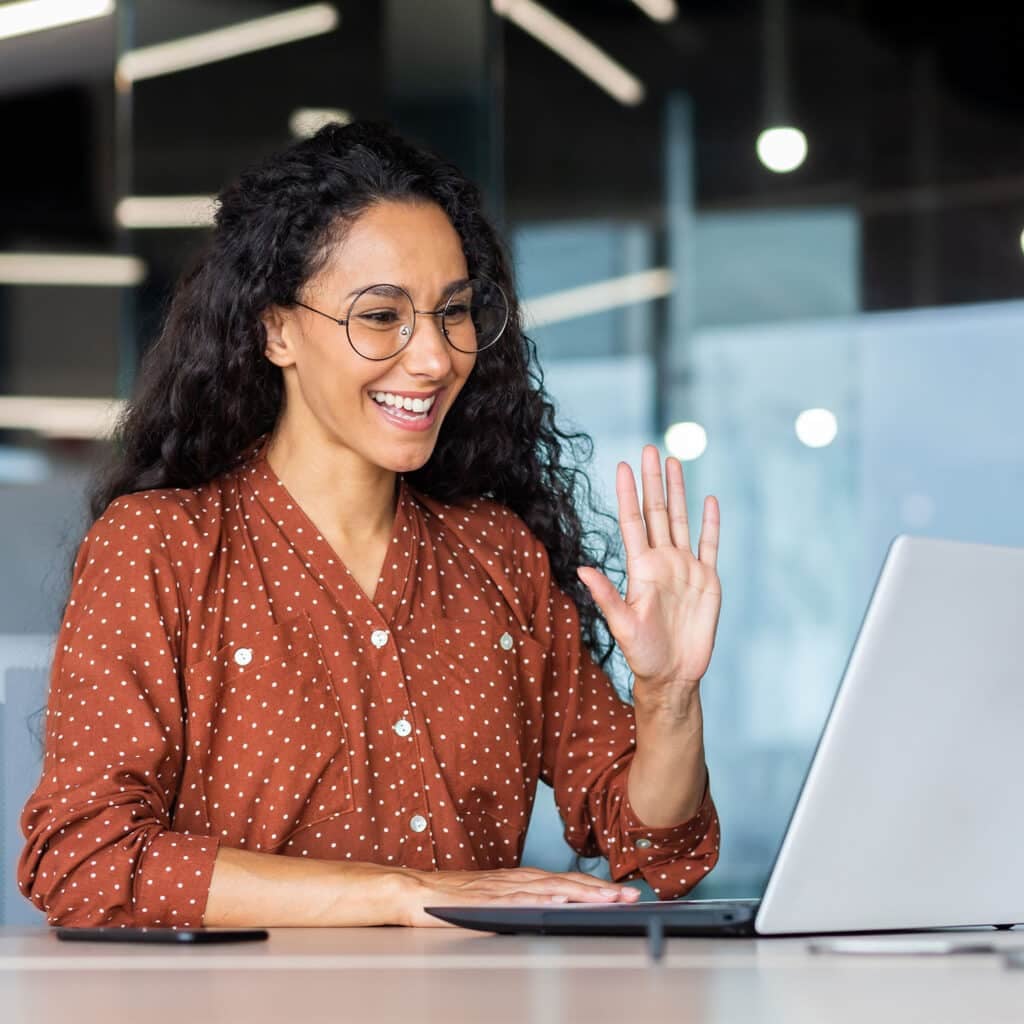 Woman working inside modern office using laptop for video interview